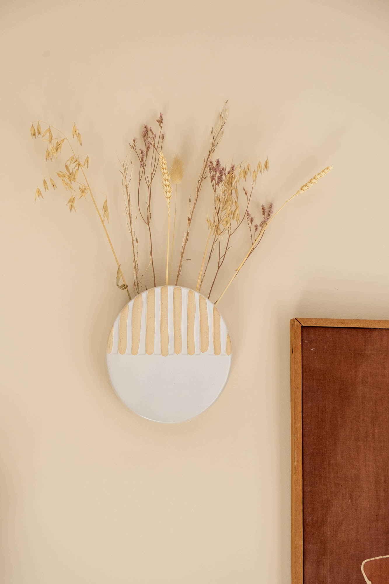vaasje aan de muur met droogbloemen